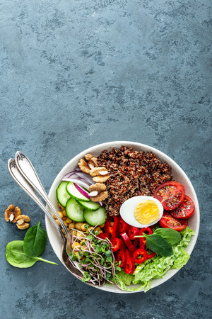 Healthy salad Buddha bowl dish of pepper, tomato, cucumber, chickpea, chia, sprouts, savoy and nuts. Healthy eating trend, superfood. Top viewの写真素材