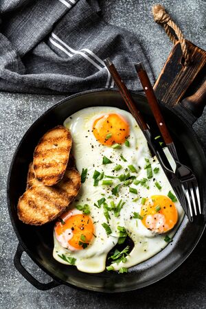 fried eggs in a cast iron pan top viewの写真素材