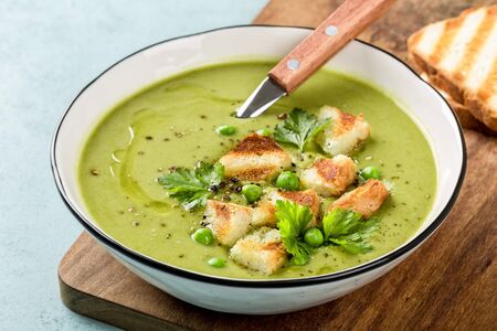 Pea soup. Green pea puree soup in a bowl served with grilled toasts, top viewの写真素材