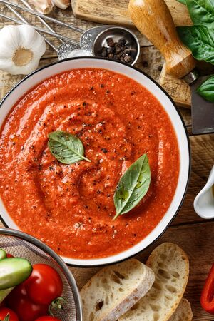 Gazpacho soup. Traditional spanish cold tomato soup of fresh raw vegetables with cooking ingredients on a wooden table top viewの写真素材