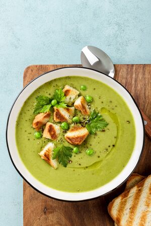 Pea soup. Green pea puree soup in a bowl served with grilled toasts, top viewの写真素材
