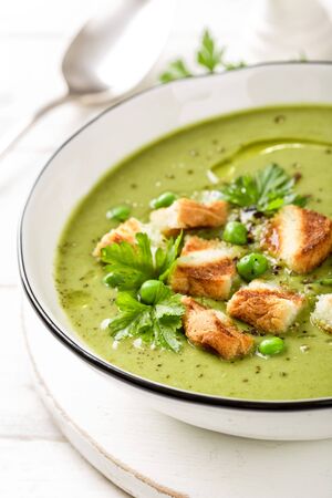 Pea soup. Green pea puree soup in a bowl served with grilled toasts, top viewの写真素材