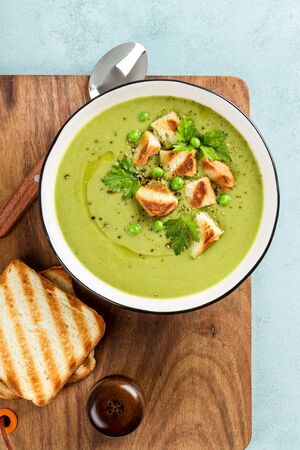Pea soup. Green pea puree soup in a bowl served with grilled toasts, top viewの写真素材