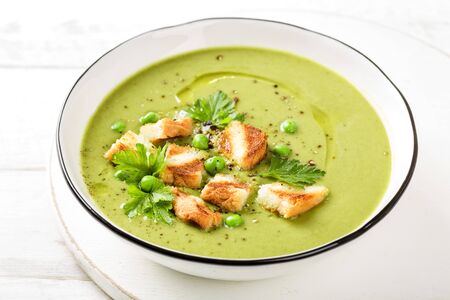 Pea soup. Green pea puree soup in a bowl served with grilled toasts, top viewの写真素材