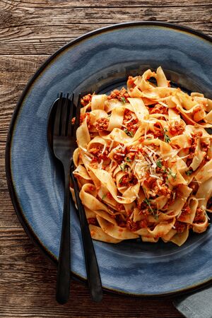 Pasta bolognese. Traditional italian dish of pasta with tomato and meat mince sauce served in a plate with parmesan cheese and thyme, top viewの写真素材
