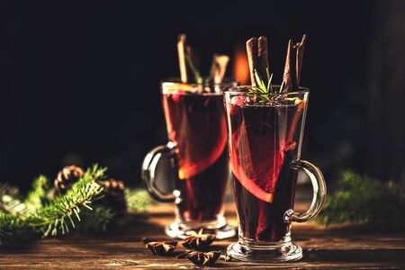 Mulled wine with spices in glasses on a rustic wooden table. Winter drink traditional for the Christmas holidays.の写真素材