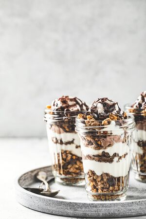 Yogurt parfait with granola, chocolate and ice cream. Sweet delicious breakfastの写真素材