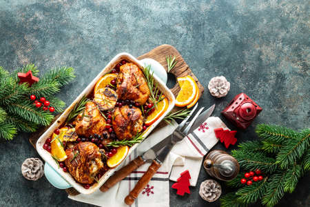 Christmas turkey legs baked with cranberries, orange and rosemary. Delicious festive dish for Christmas time. Top view, christmas food background with space for a textの写真素材