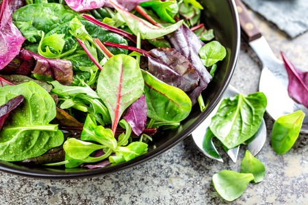 Salad bowl, healthy food. Fresh salad mix of baby spinach, arugula leaves, basil, chard and lambs lettuce.の写真素材