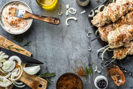 shish kebab in marinade and spices, pickled raw meat on skewers, culinary background, cooking recipe for grillの写真素材