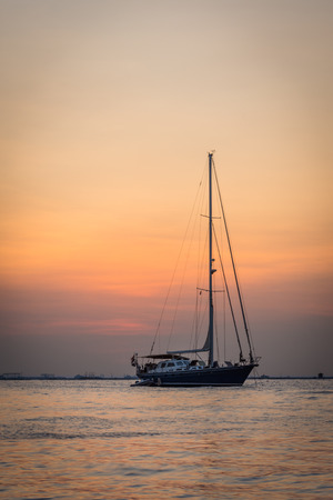 A boat with a colorful sunset sky at Mutiara Beachの写真素材