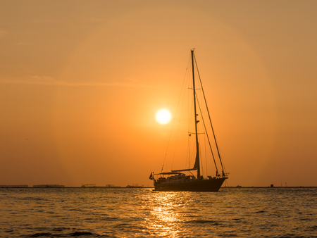 A boat silhouette against sunset sky at Mutiara Beachの写真素材