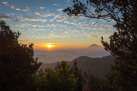 Warm morning sunrise on Ghober Hut campsite with view of mount Cikuray. Beautiful landscape of mount Papandayan. Papandayan Mountain is one of the favorite place to hike on Garut.の写真素材