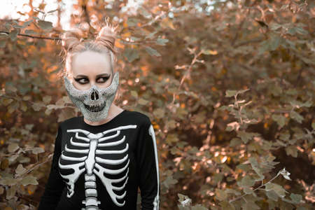Girl dressed as a skeleton in the autumn forest. Portrait. Close-up. Halloweenの写真素材