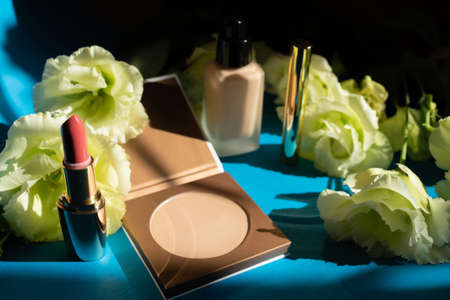 Decorative cosmetics. Face powder on a blue background. Rose flowers decorationの写真素材