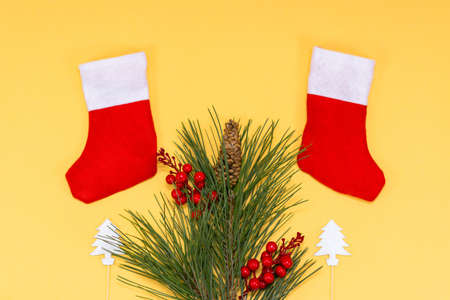 Merry christmas concept, two red socks with fir branches on a light beige background.copy space