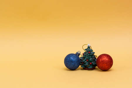 Merry Christmas and Happy Holidays . Christmas tree with balls on a yellow background. Festive themeの写真素材