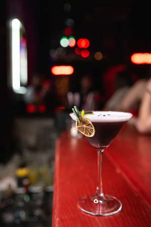 Alcoholic cocktail decorated with dried orange and mint. Night club, close-upの写真素材