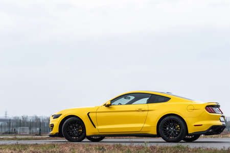 Yellow with black stripes Ford Mustang muscle car in a parking lot. General plan, side view. Russia, Rostov-on-Don 23 Oct2021のeditorial素材