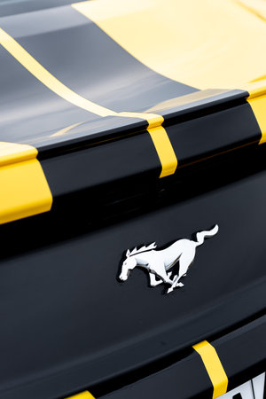 Yellow with black stripes Ford Mustang muscle car in a parking lot. Close-up of the logo. Russia, Rostov-on-Don 23 Oct2021のeditorial素材