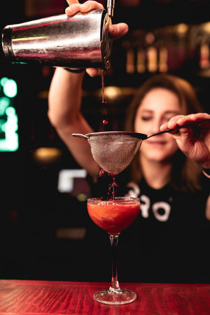 Girl bartender prepares a beautiful red cocktail. spray. Night club, bar. Russia, Rostov-on-Don, 22Jan2022のeditorial素材