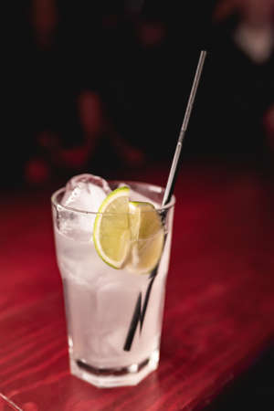 Alcoholic cocktail with lemon in a nightclubの写真素材
