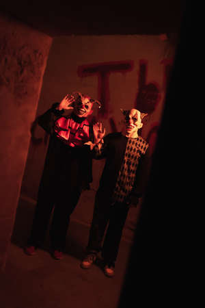 Two evil clowns stand frighteningly in a dark corridor and wave their hand. Game quest concept. Russia, Rostov-on-Don 30Jan2022のeditorial素材