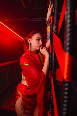 A beautiful girl in a kimono stands near red ribbons. The image of a geisha, Chinese national costume. Party concept, night club. Russia, Rostov-on-Don 5feb2022のeditorial素材