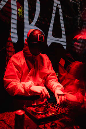 DJ in a squid games-themed costume plays at the party. Red lighting. Party concept, night club. Russia, Rostov-on-Don 5feb2022のeditorial素材