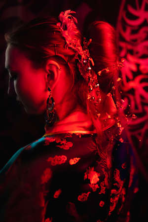 Beautiful girl in a kimono in red light. Close-up of hair with decorations. Geisha image. Party concept, night club. Russia, Rostov-on-Don 5feb2022のeditorial素材