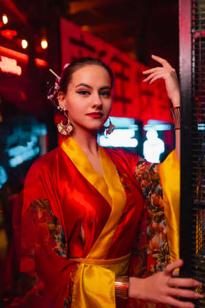 Attractive girl in a kimono. Image of a geisha, Chinese national costume. Party concept, night club....
