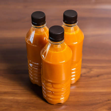 Useful sea buckthorn juice is poured into bottles on a wooden table. country styleの写真素材