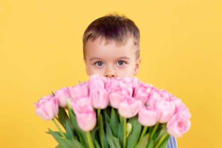 Cute little boy with a bouquet of flowers. Tulips. mother's day. International Women's Day. Portrait...