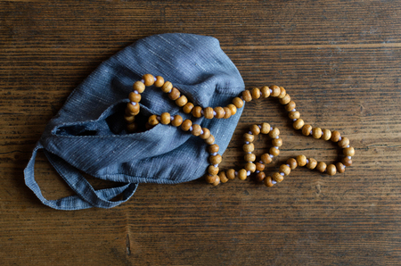 Wooden rosary. Wooden rosary in blue bag on a wooden floorの写真素材