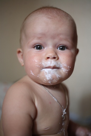 Portrait of the baby with the soiled cottage cheese the faceの写真素材