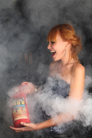 The girl extinguishes a fire the fire extinguisherの写真素材