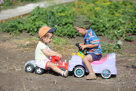 boy and girl on toy cars involved in an accidentの写真素材