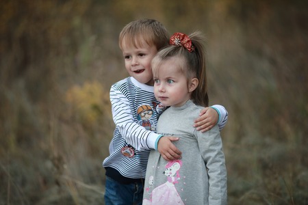 little boy gently hugs her little sisterの写真素材