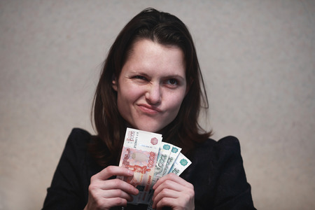 girl looks skeptically at the wad of billsの写真素材