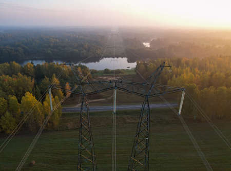 AERIAL VIEW: over the support of a high-voltage power line with wires thrown across a river in a...