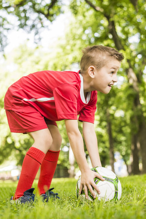 Young boy holding football in his handの写真素材
