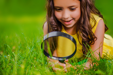 Little girl exploring through magnifying glassの写真素材