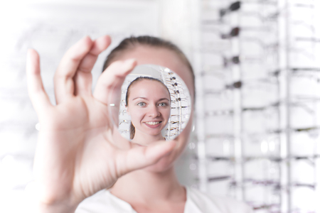 Woman looking through a lensの写真素材