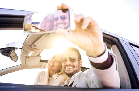 Cropped shot of an affectionate young couple taking a selfie in the carの写真素材