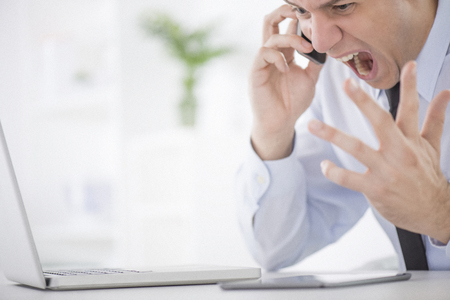 Businessman looking frustrated at the officeの写真素材