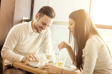 Happy couple on a date looking at something online on digital tablet.They are enjoying together and having a great time.の写真素材