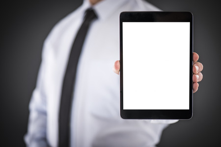 Male hands hold digital tablet with isolated screen. His face is not visible. He is wearing a white...