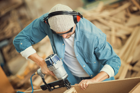 Carpenter working on a plank of wood in his workshop