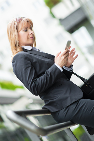 Close up shot of a woman typing a text on mobile phone.の写真素材