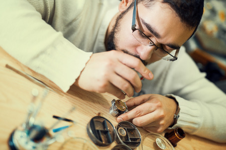 Close up portrait of a watchmaker at work.A watchmaker or repair man in action,viewing very closely.